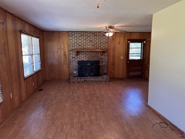 139AND137 Ga Highway 257, Cochran, GA 31014 - unfurnished living room featuring wood finished floors, wooden walls, ceiling fan, baseboards, and a textured ceiling