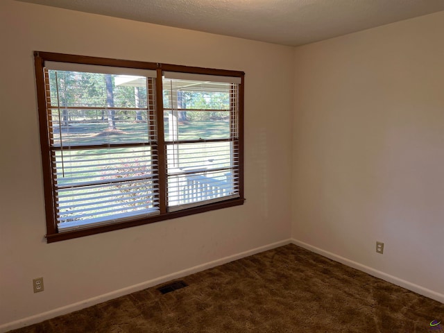 unfurnished room with dark carpet