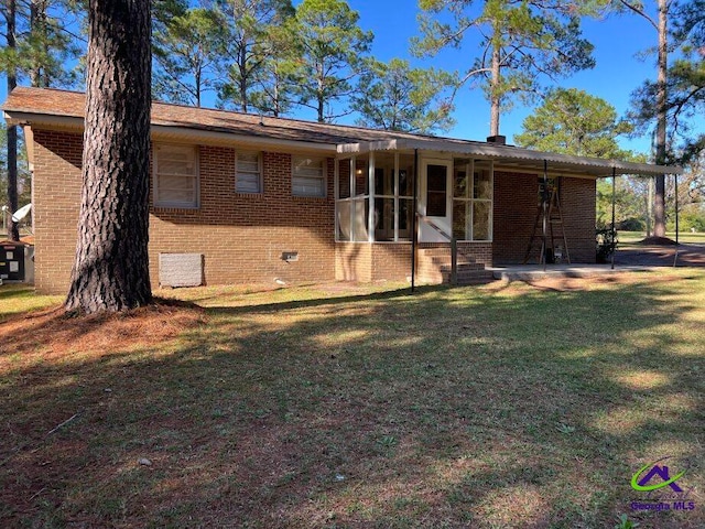 view of front facade featuring a sunroom and a front lawn