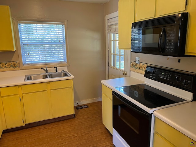 kitchen featuring light wood-type flooring, white electric range, and sink