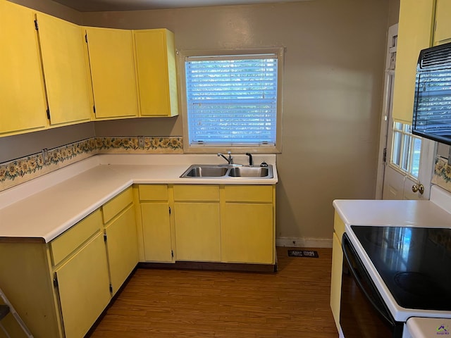 kitchen with white range oven, sink, and light hardwood / wood-style flooring