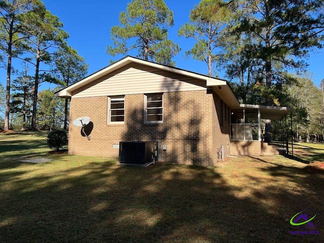 view of side of home with a sunroom, a yard, and cooling unit