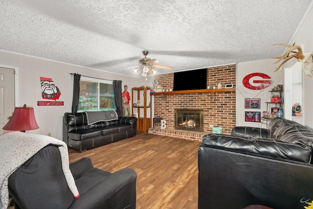 living room with ceiling fan, a fireplace, a textured ceiling, and hardwood / wood-style flooring