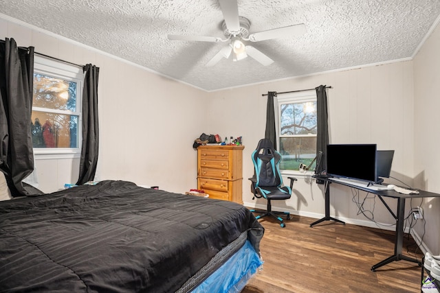 bedroom with a textured ceiling, hardwood / wood-style flooring, ceiling fan, and ornamental molding