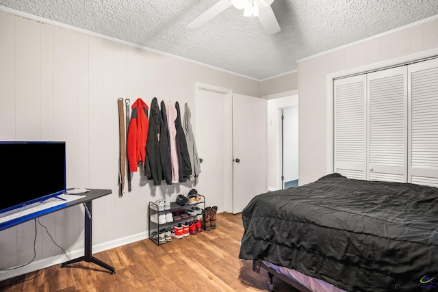 bedroom with hardwood / wood-style floors, ceiling fan, ornamental molding, and a textured ceiling