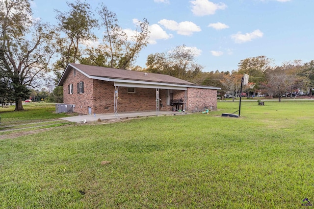 rear view of house featuring a yard and a patio