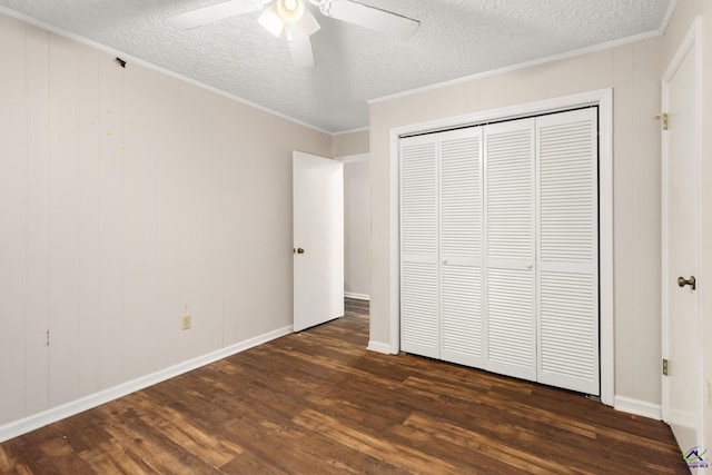 unfurnished bedroom with dark hardwood / wood-style floors, ceiling fan, ornamental molding, and a closet