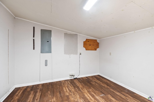 empty room featuring dark hardwood / wood-style flooring, electric panel, and ornamental molding