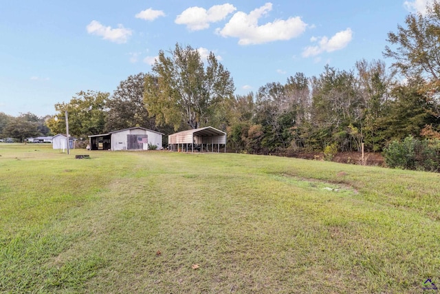 view of yard featuring a carport and an outdoor structure