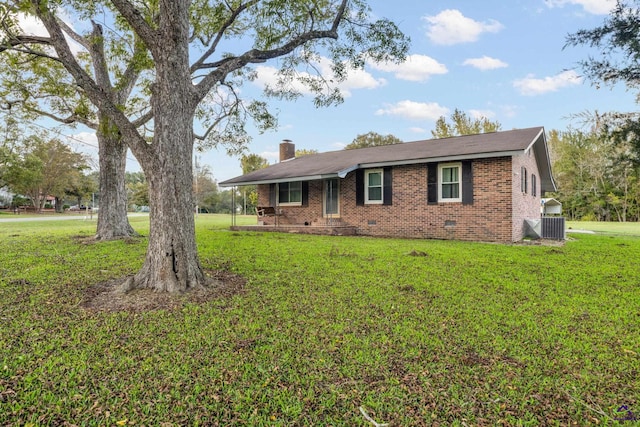 ranch-style house featuring cooling unit and a front lawn