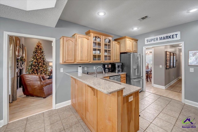 kitchen featuring light stone countertops, a textured ceiling, and stainless steel appliances