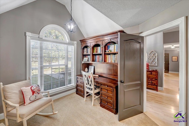 office with a notable chandelier, light wood-type flooring, lofted ceiling, and a textured ceiling