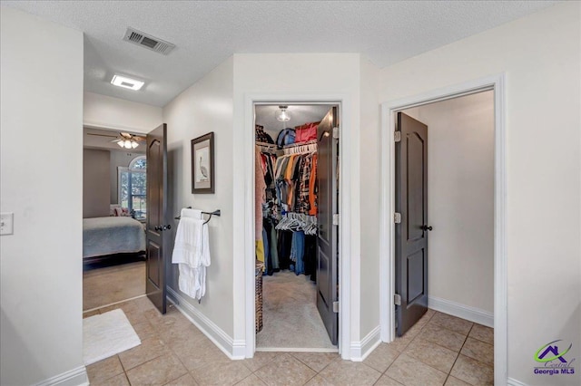 corridor featuring light tile patterned floors and a textured ceiling