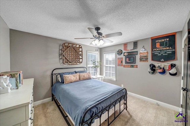 bedroom with ceiling fan, a textured ceiling, and light carpet