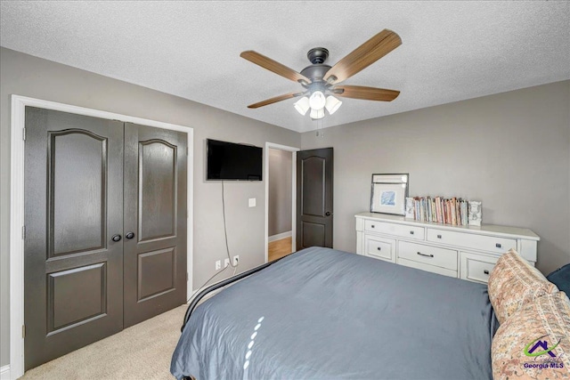 bedroom featuring ceiling fan, a closet, and a textured ceiling