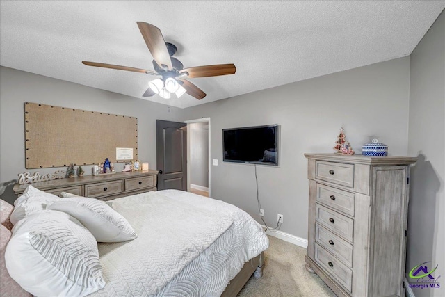 carpeted bedroom featuring ceiling fan and a textured ceiling