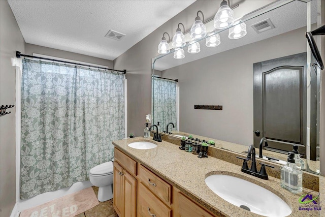 bathroom featuring vanity, a textured ceiling, toilet, and tile patterned flooring