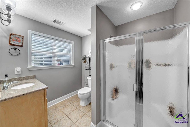 bathroom with vanity, tile patterned floors, toilet, a textured ceiling, and walk in shower