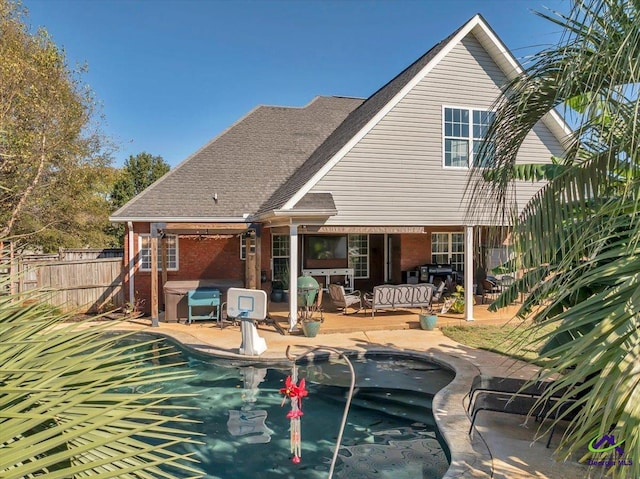 rear view of property with an outdoor living space, a fenced in pool, and a patio area