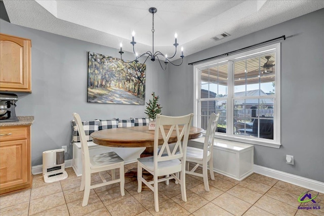 tiled dining room featuring a textured ceiling and an inviting chandelier