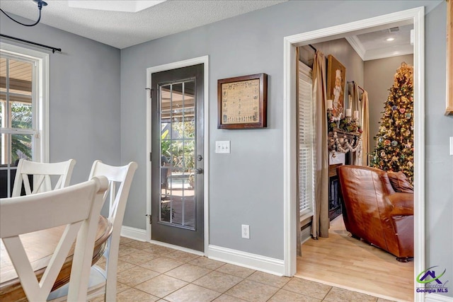 interior space with light tile patterned floors, a textured ceiling, and a healthy amount of sunlight