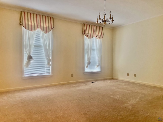 carpeted spare room featuring a notable chandelier