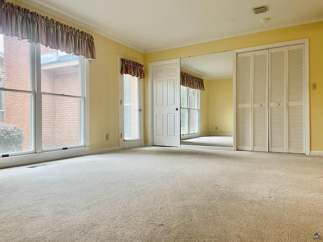 unfurnished bedroom featuring light carpet, multiple windows, and ornamental molding