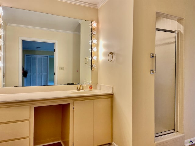 bathroom featuring vanity, a shower with shower door, and ornamental molding