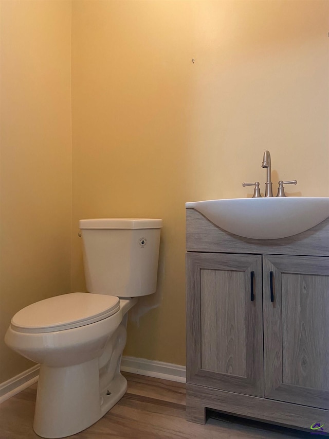 bathroom with vanity, toilet, and wood-type flooring