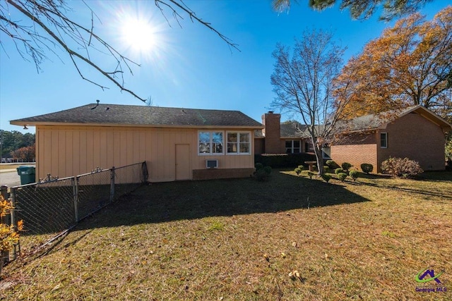 rear view of property featuring a lawn