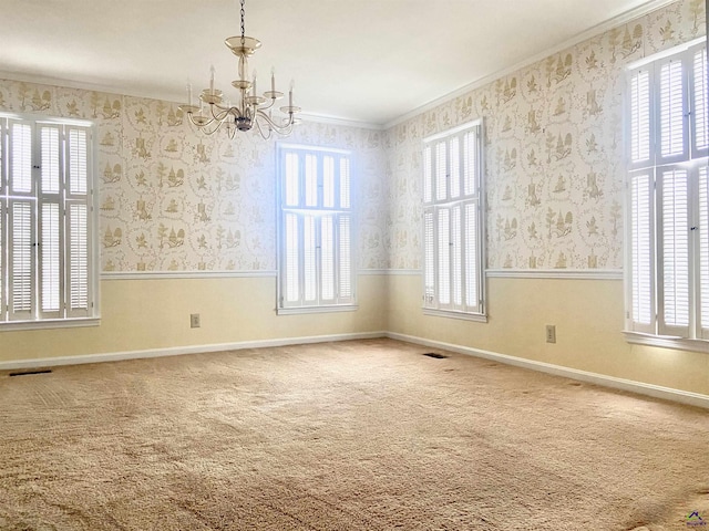 carpeted empty room featuring ornamental molding and a notable chandelier