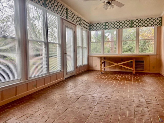 unfurnished sunroom with ceiling fan