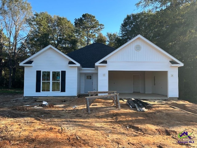 view of front of house featuring a garage, driveway, and roof with shingles