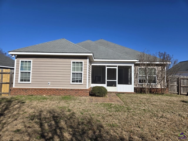 back of house featuring a lawn and a sunroom