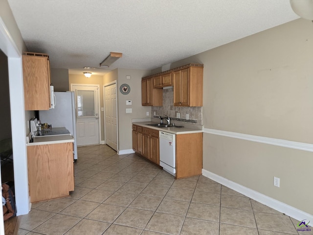 kitchen featuring backsplash, sink, white appliances, a textured ceiling, and light tile patterned floors