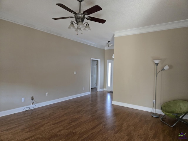 spare room featuring ceiling fan, dark wood-type flooring, and ornamental molding