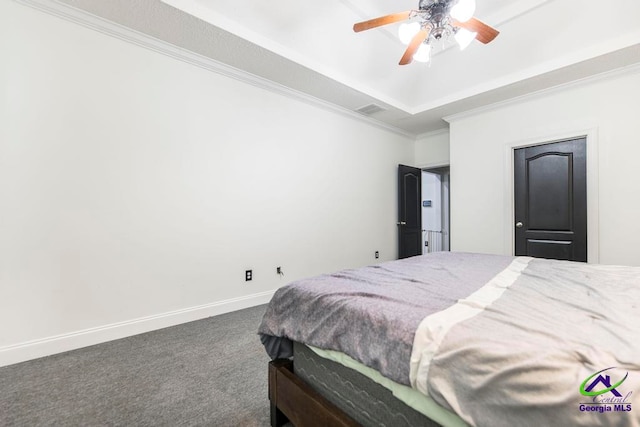 carpeted bedroom with a raised ceiling, ceiling fan, and crown molding