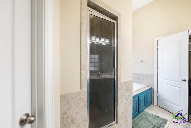 bathroom with tile patterned floors, sink, plus walk in shower, and tile walls