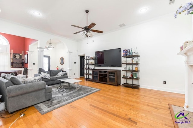 living room with ornate columns, ceiling fan, crown molding, and hardwood / wood-style flooring