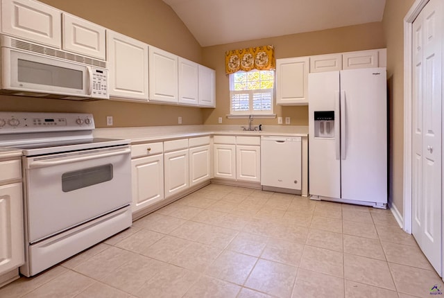 kitchen with white appliances, sink, vaulted ceiling, light tile patterned floors, and white cabinetry