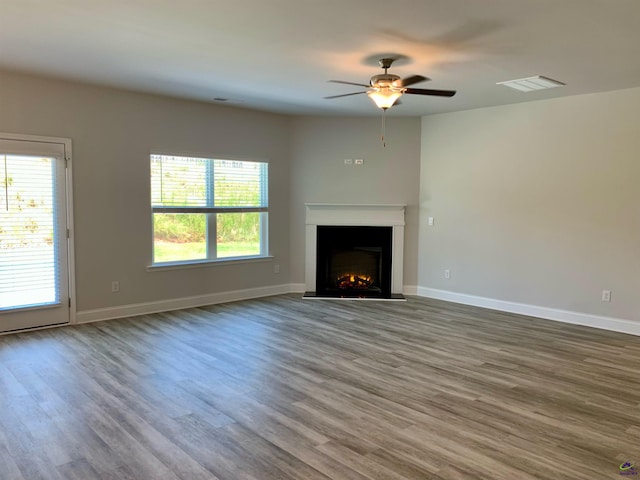 unfurnished living room with ceiling fan and wood-type flooring