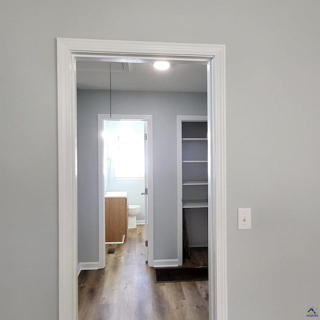 corridor with hardwood / wood-style floors