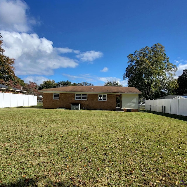 back of house with a yard and central AC unit