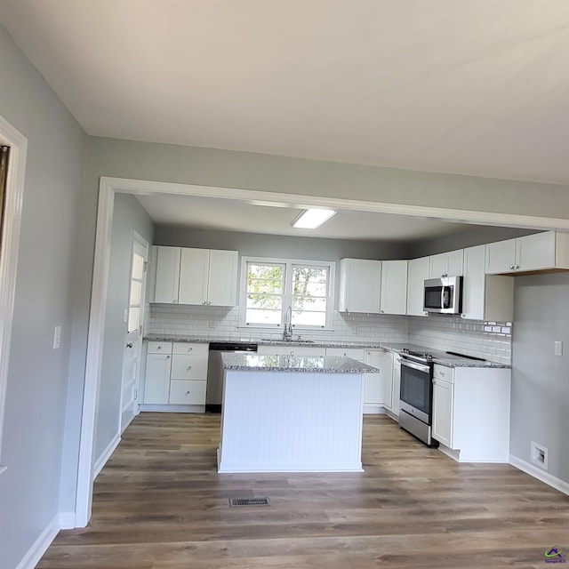 kitchen featuring hardwood / wood-style flooring, sink, white cabinets, and appliances with stainless steel finishes