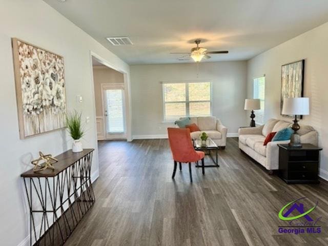 living room featuring ceiling fan and dark hardwood / wood-style floors