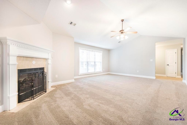 unfurnished living room with light carpet, ceiling fan, lofted ceiling, and a tiled fireplace