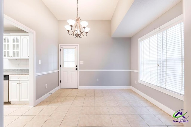 interior space with a notable chandelier, light tile patterned flooring, and a wealth of natural light