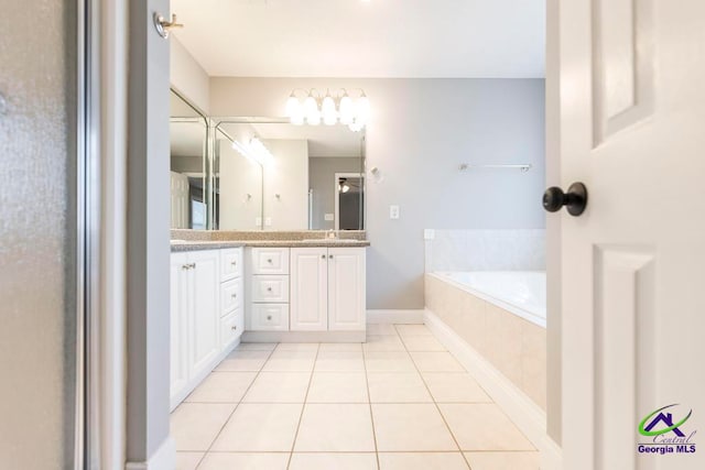 bathroom with tile patterned floors, tiled bath, and vanity