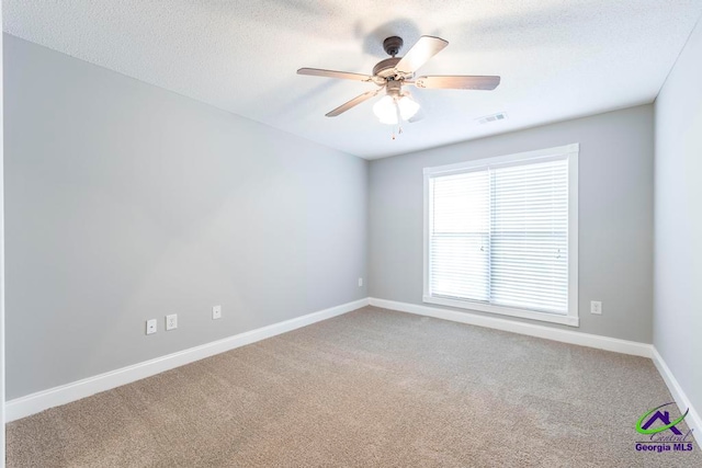 empty room featuring ceiling fan, carpet floors, and a textured ceiling