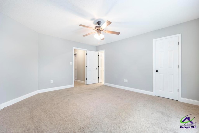 unfurnished bedroom featuring light carpet and ceiling fan